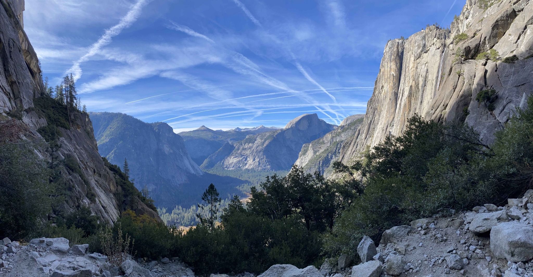 View across Yosemite Valley, with Half Dome and granite cliffs beneath a blue sky